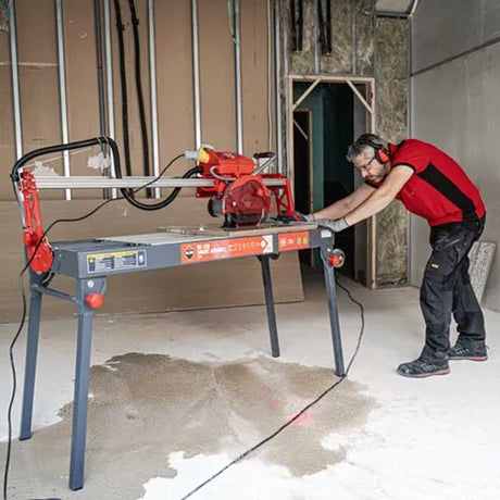Person using a tile cutting machine in a room under construction